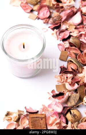 photo a lot of dried plants and a lit pink candle Stock Photo