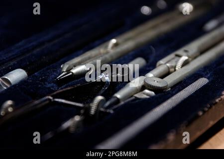 set of divider, compass inside a box for geometric construction lying on wooden table Stock Photo