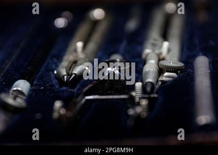 set of divider, compass inside a box for geometric construction lying on wooden table Stock Photo