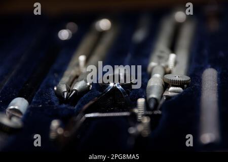 set of divider, compass inside a box for geometric construction lying on wooden table Stock Photo