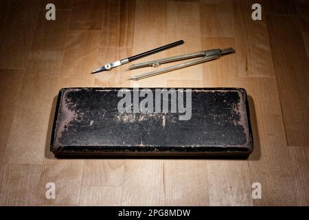 set of divider, compass inside a box for geometric construction lying on wooden table Stock Photo