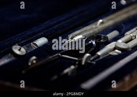 set of divider, compass inside a box for geometric construction lying on wooden table Stock Photo