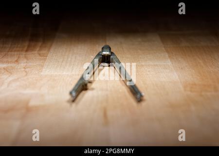 divider. compass for geometric construction lying on wooden table Stock Photo
