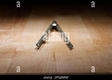 divider. compass for geometric construction lying on wooden table Stock Photo
