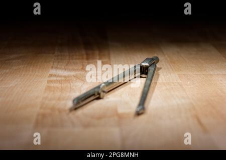 divider. compass for geometric construction lying on wooden table Stock Photo