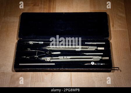 set of divider, compass inside a box for geometric construction lying on wooden table Stock Photo