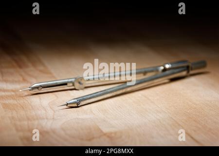 divider. compass for geometric construction lying on wooden table Stock Photo