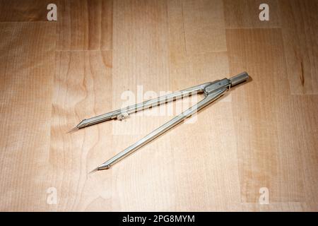divider. compass for geometric construction lying on wooden table Stock Photo