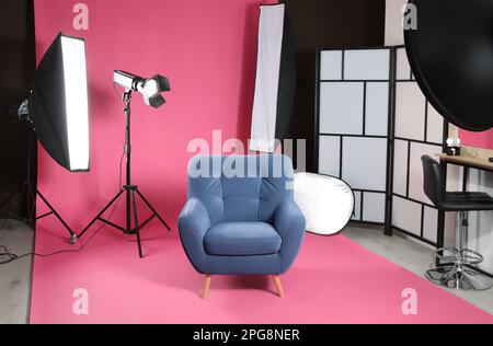 Stylish blue armchair in photo studio with professional equipment Stock Photo