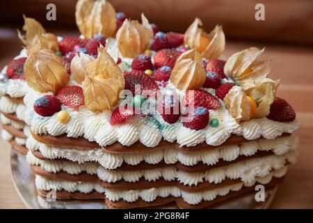 Strawberries and raspberries on a cake with whipped cream close-up. Stock Photo