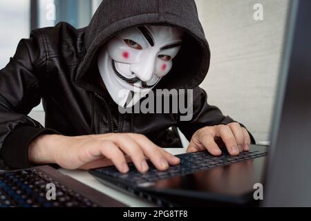 Hacker sitting behind computer. Anonymous Hacking computer networks. June 1, 2022. Barnaul. Russia. Stock Photo