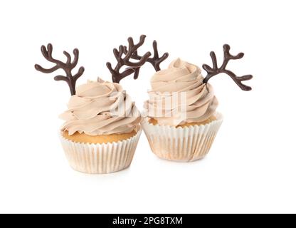 Delicious Christmas cupcakes with chocolate reindeer antlers on white background Stock Photo