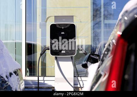 Two electric cars plugged in DEFA charger with two outlets to recharge battery. Salo, Finland. March 12, 2023. Stock Photo