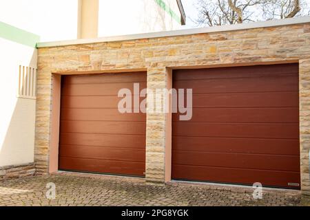 Two red sectional doors from the german manufacturer Hörmann on the garage of a detached house (Neustadt, Germany, March 18, 2023) Stock Photo