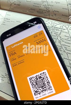 Airplane flight digital boarding pass FRA-MAN on mobile phone, with Lufthansa, and rail transport map of Manchester, North West England Stock Photo