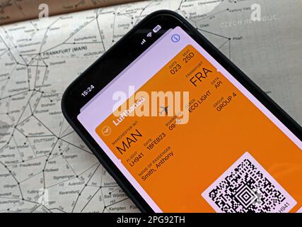 Airplane flight digital boarding pass MAN-FRA on mobile phone, with Lufthansa, and rail transport map of Frankfurt, Germany Stock Photo