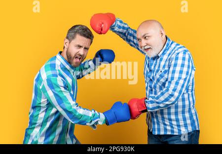 image of generation men disagreement. two generation men has disagreement isolated on yellow. Stock Photo