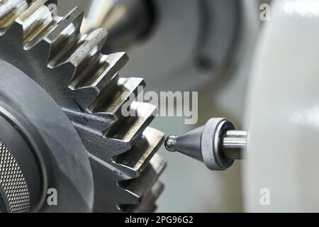 Grey cogwheel and oil nozzle in manufacturing workshop Stock Photo