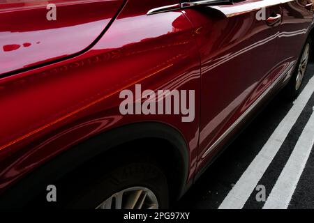 White lines reflected on the side of a red car parked on a New York City street Stock Photo