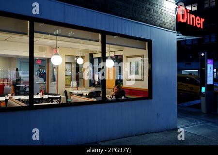 Woman in a New York City diner at night Stock Photo