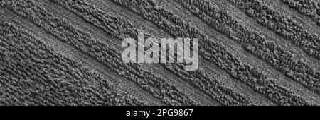 Gray terry towel fabric texture banner. Textile background, top view panoramic web header. Wide screen wallpaper Stock Photo