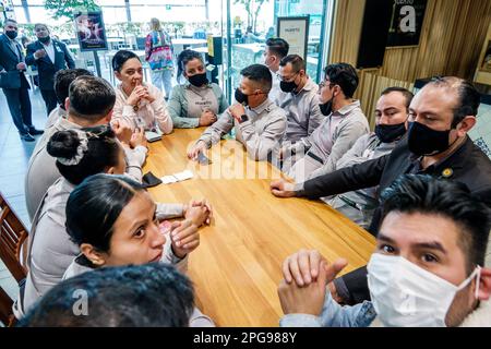 Mexico City,Polanco,El Palacio de Hierro,luxury department store,food court hall,waitress waiter server pre-shift meeting huddle,man men male,woman wo Stock Photo