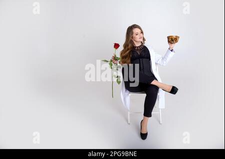 attractive holds a skull in her hands concept of photography is suitable in the field of cosmology, medicine and healthcare Woman in a white robe and black evening dress beautiful bright fierce Stock Photo