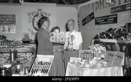 https://l450v.alamy.com/450v/2pg9fpy/1956-historical-on-an-exhibition-stand-for-cookware-distributors-saladmaster-a-couple-standing-as-the-man-is-presented-with-a-rosette-celebrating-the-50th-anniversary-of-the-lane-county-fair-eugene-oregon-usa-stainless-steel-cutlery-and-bavarian-china-is-on-display-the-business-started-in-1947-with-one-product-the-saladmaster-machine-and-expanded-its-range-of-cookware-to-become-one-of-the-top-100-companies-in-texas-by-the-1970s-2pg9fpy.jpg