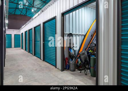 Outdoors activity items seen through the open door of the self storage unit. Rental Storage Units Stock Photo