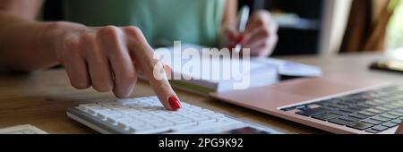 Woman hand using a calculator and letter makes note with cost calculation in home office Stock Photo