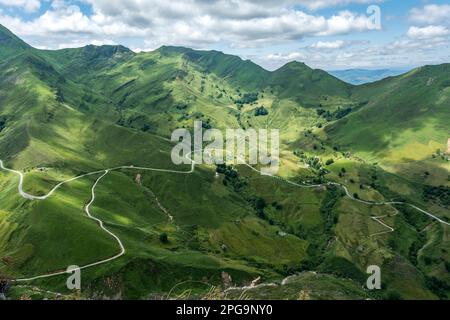 Green mountain landscape with curvy road in Cantabria, Spain Stock Photo