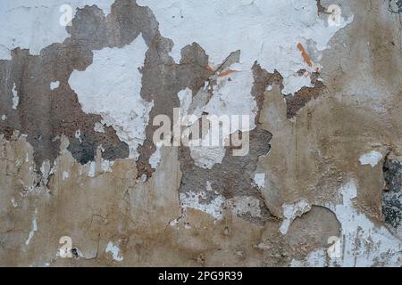 Old concrete wall with worn out limewash peeling plaster Stock Photo