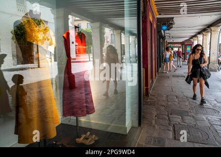 A woman walks along the booksellers street lined with fashion stores in Alcala de Henares Madrid Spain Stock Photo