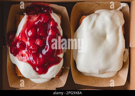 Cherry Frosted cinnamon roll, and Cream Cheese cinnamon roll close up, flat lay Stock Photo