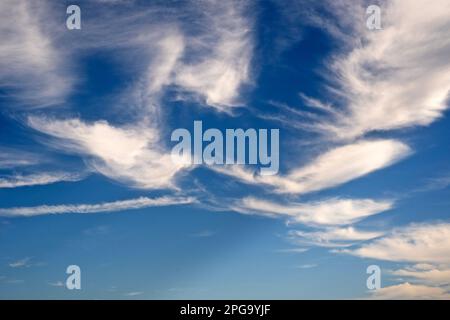 Clouds float by in a blue sky. Stock Photo