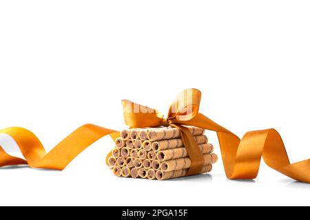Crispy wafer rolls with chocolate are stacked and tied with a ribbon isolated on a white background. Wafers with creamy chocolate filling. Stock Photo