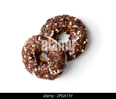 Two donuts in chocolate glaze sprinkled with pieces of white, milk and dark chocolate isolated on a white background top view. High-calorie junk food. Stock Photo