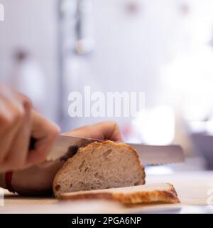Caucasian man cutting bread on board Stock Photo