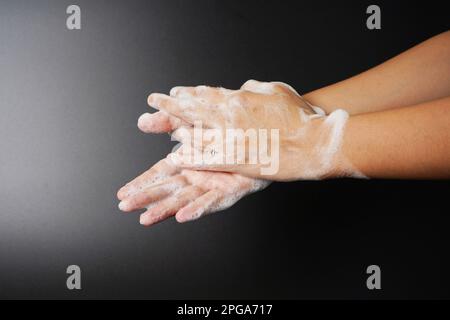 Washing hand with soap on dark background Stock Photo