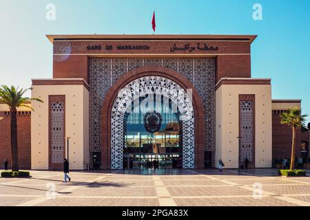 Marrakech, Morocco - January 02, 2020: Ornaments decorating walls of Marrakesh railway station, sun shines on pavement leading to large glass entrance Stock Photo