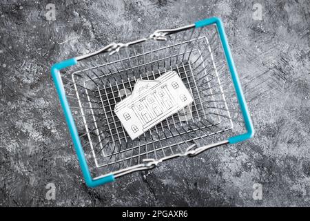 financial institution merging and holdings concept, bank made of paper inside of shopping basket ready to be bought by a competitor Stock Photo