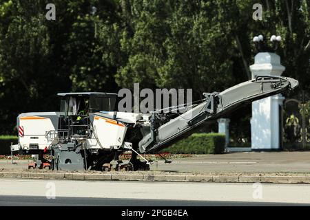 Cold milling machine on city street. Road repair service Stock Photo
