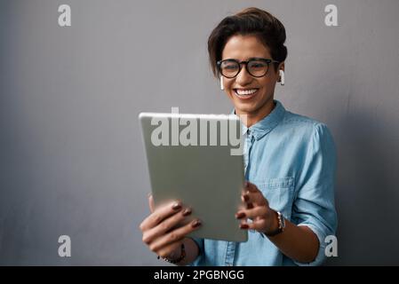 Another deal done for the day. an attractive young businesswoman standing alone and using a digital tablet. Stock Photo