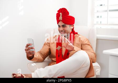 Bye bye bachelorhood, hello happily ever after. a young man waving while using a smartphone on his wedding day. Stock Photo
