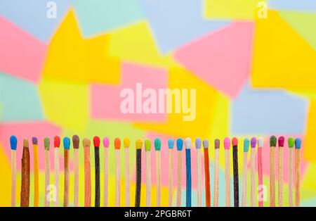 matchsticks of various shapes and colors with multicolored paper sticky notes on background Stock Photo