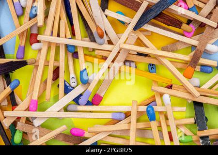 matchsticks of various shapes and colors with multicolored paper sticky notes on background Stock Photo