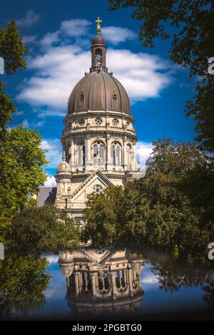 A vertical shot of The Christuskirche reflecting on a pond in Mainz, Germany Stock Photo