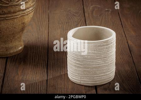 Clay jug for wine and a glass on a dark wooden background. Stock Photo