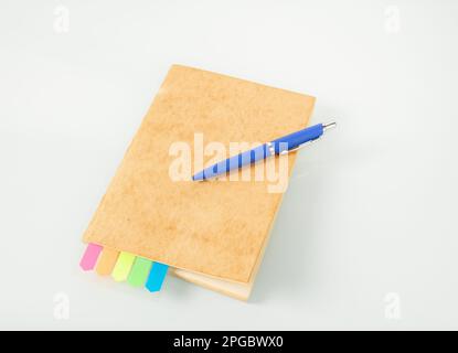 Office tools. Notebook with colored bookmarks and a blue fountain pen on a light background. Stock Photo