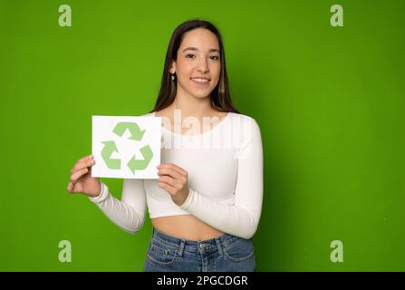 Young caucasian woman girl eco-activist holding recycling logo sign for sorting garbage paper plastic, environmental conservation saving planet from c Stock Photo